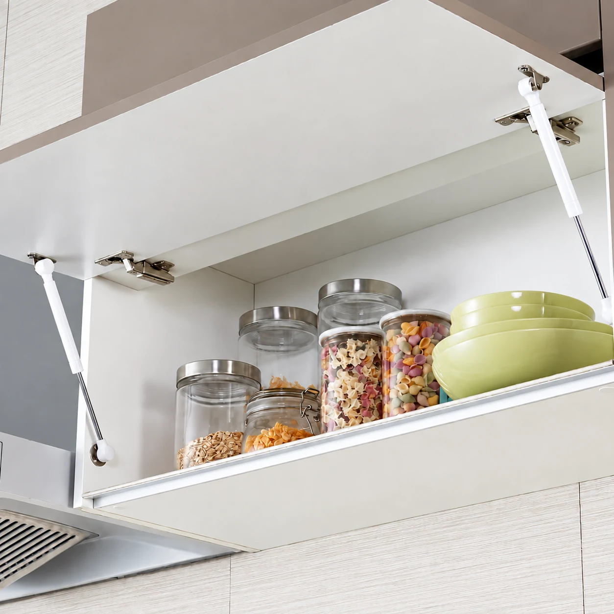 Gas springs supporting an open cabinet door